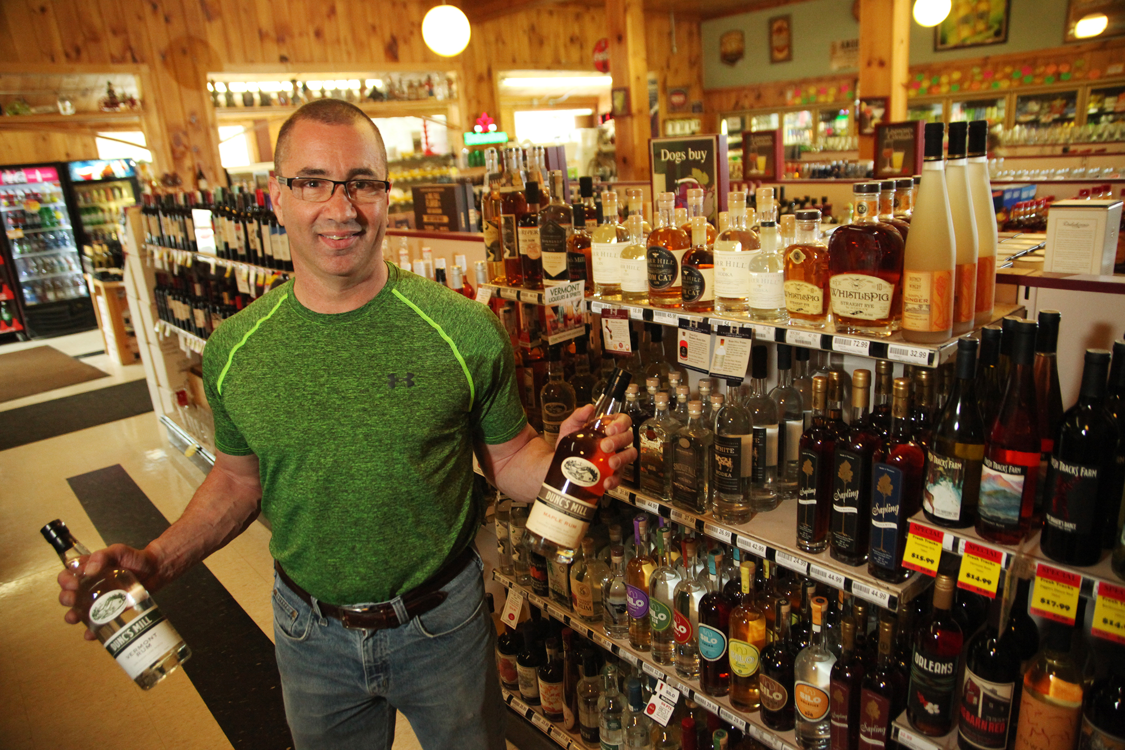 human standing in liquor store holding bottles